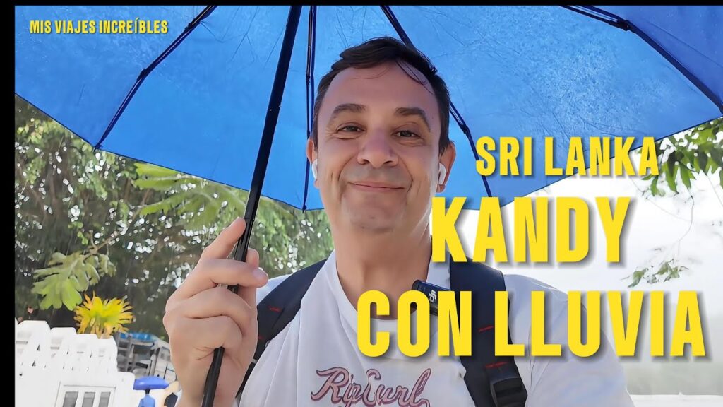 Guille (Guillermo Daniel García Lu Bello) sonriendo bajo un paraguas azul durante un día lluvioso en Kandy, Sri Lanka, con el texto "SRI LANKA KANDY CON LLUVIA".